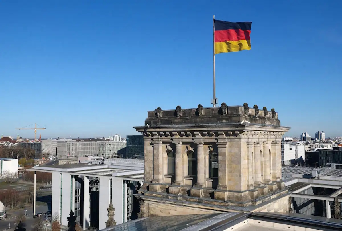 German national flag flutters on top of the Reichstag building