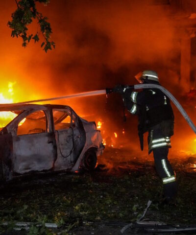 Ένας πυροσβέστης σβήνει καμένα αυτοκίνητα σε χώρο στάθμευσης μετά από επίθεση ρωσικού drone, εν μέσω της επίθεσης της Ρωσίας στην Ουκρανία