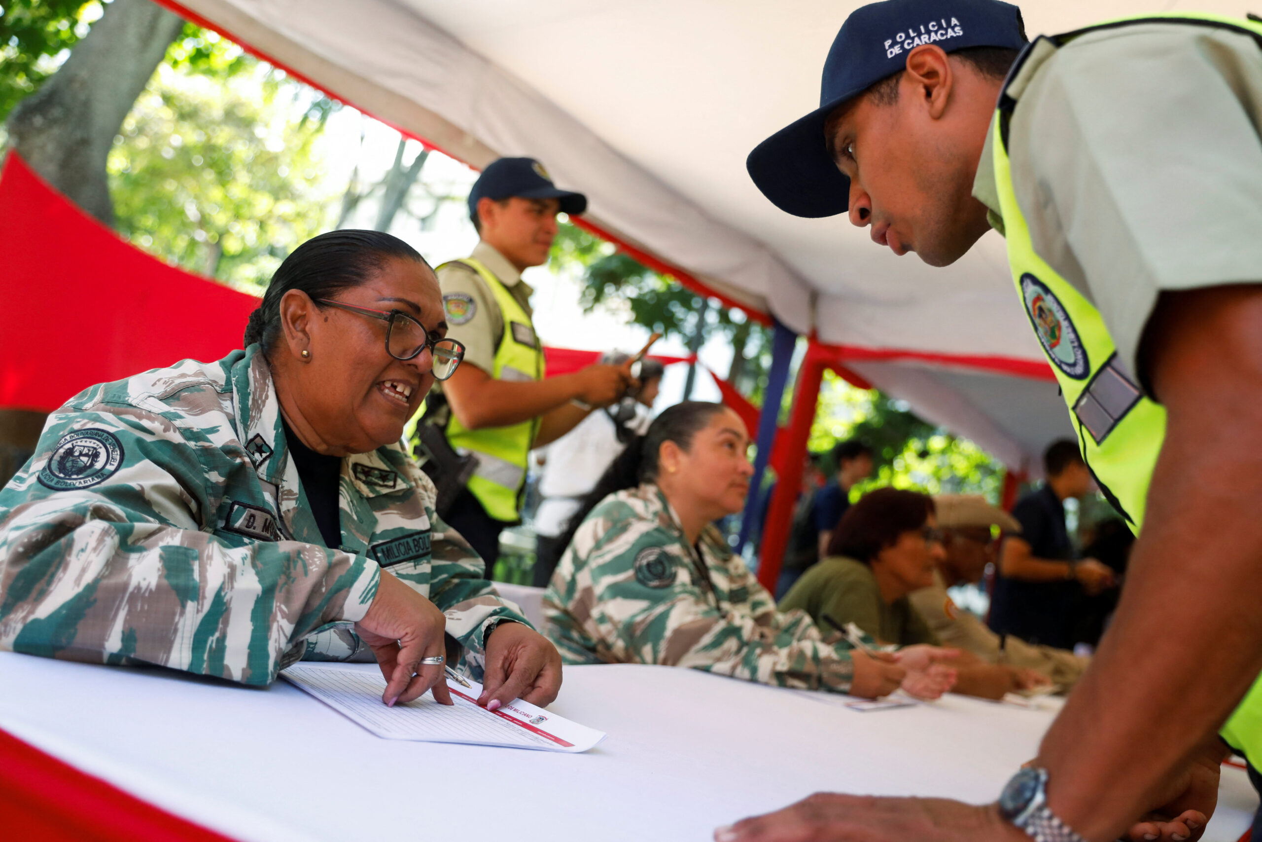 Members of the Bolivarian National National Guard help citizens classify in the National Guard