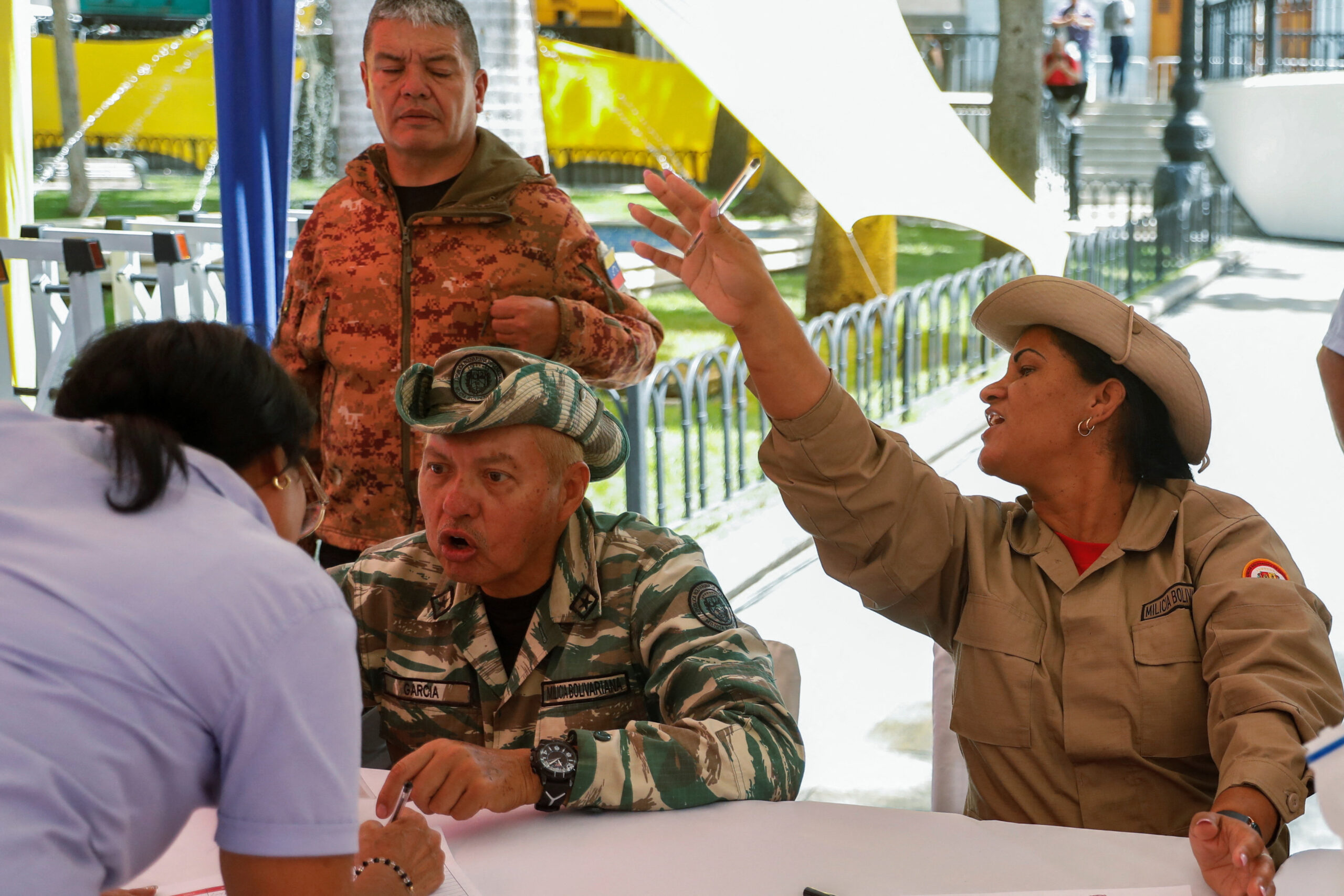 Members of the Bolivarian National National Guard help citizens classify in the National Guard