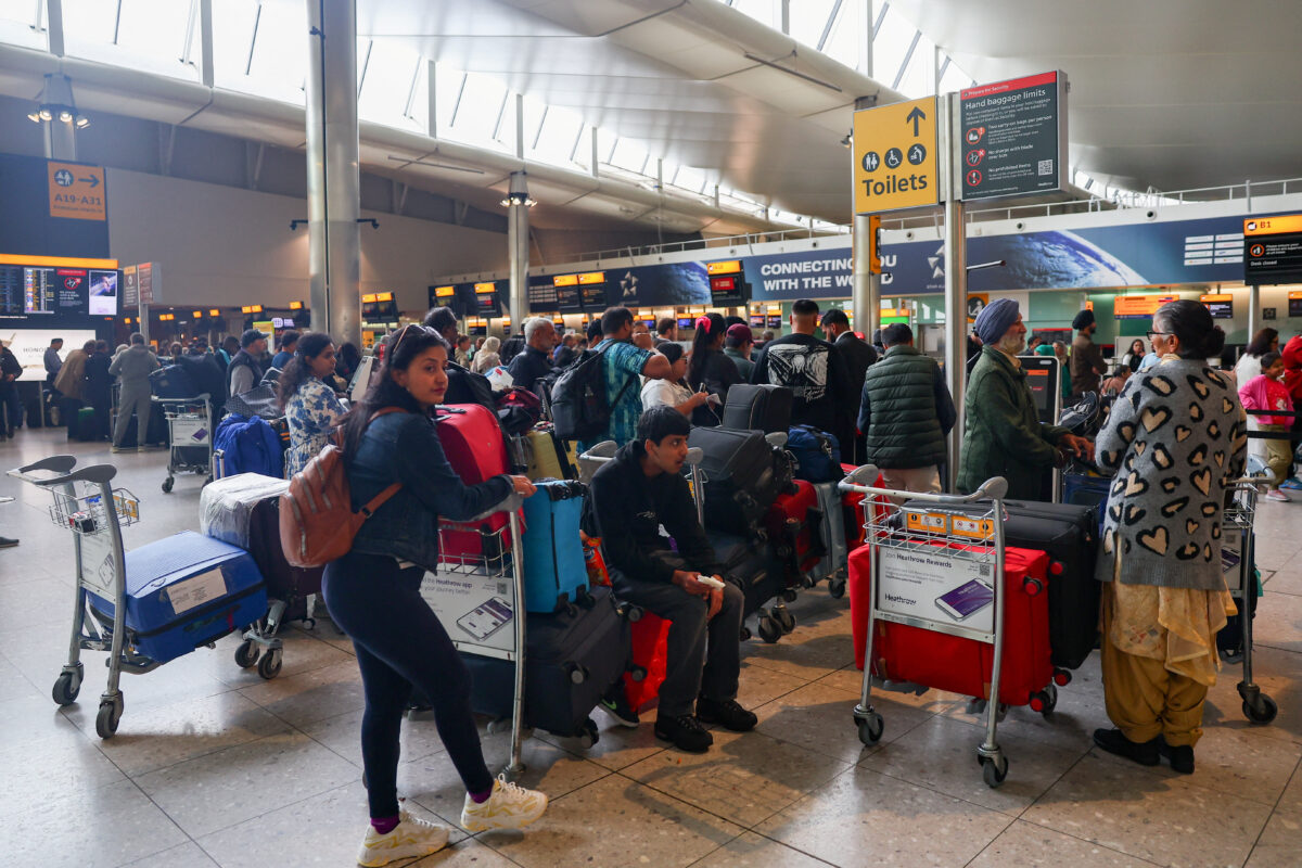 Οι ταξιδιώτες περιμένουν κοντά στα γκισέ check-in στο Τερματικό 2 του αεροδρομίου Heathrow, εν μέσω καθυστερήσεων και ακυρώσεων πτήσεων, που οφείλονται σε διακοπή των συστημάτων check-in και επιβίβασης λόγω κυβερνοεπίθεσης