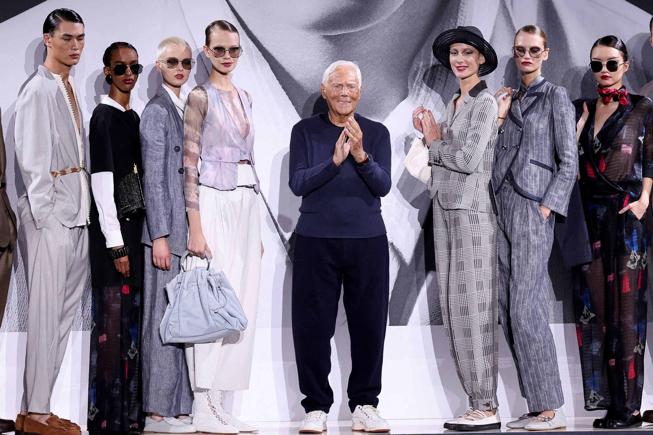 Designer Giorgio Armani stands next to models during the Emporio Armani Spring/Summer 2025 collection at the Fashion Week in Milan