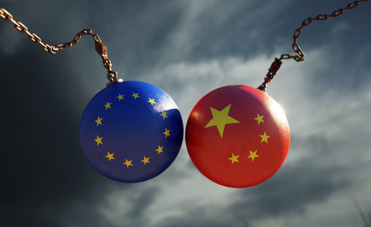 Wrecking balls textured with European Union and Chinese flags over dark stormy sky. Horizontal composition with copy space and selective focus. Dispute concept.