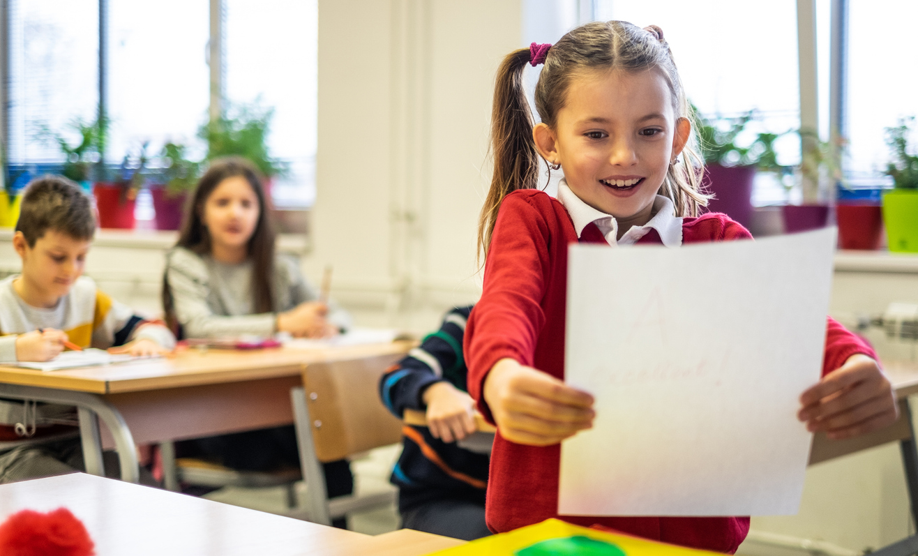 Girl is happy about her grade in classroom
