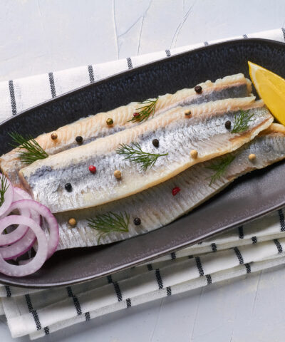 salted fillet of herring decorated with dill pepper lemon red onion