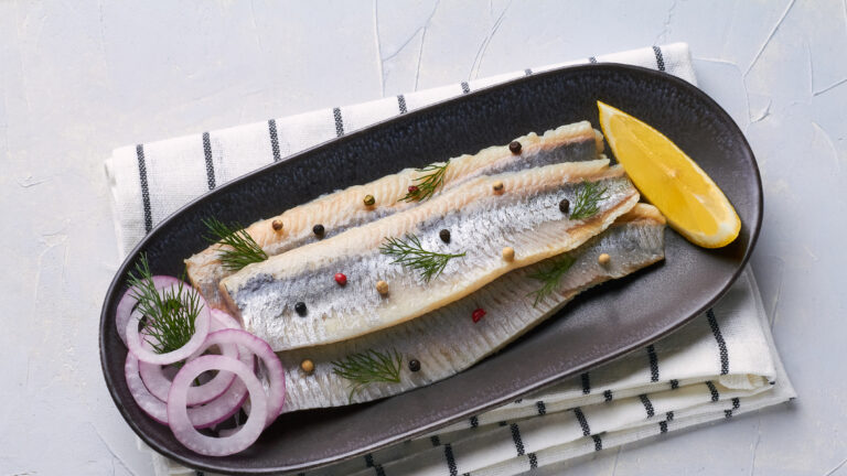 salted fillet of herring decorated with dill pepper lemon red onion