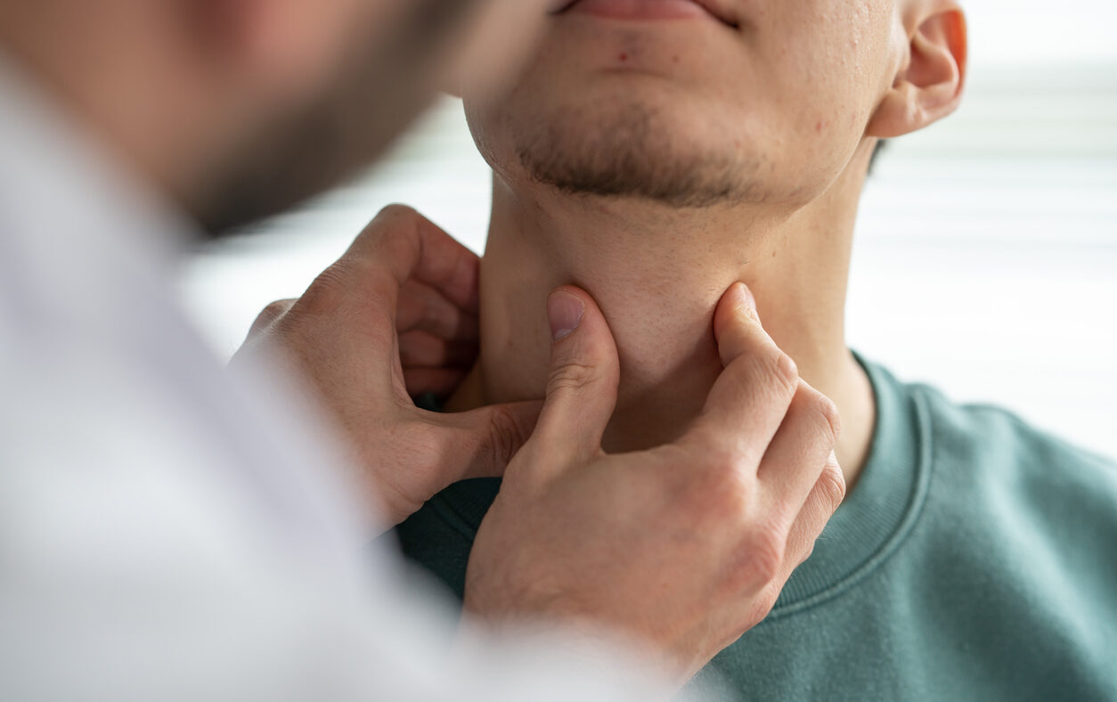 Doctor examining patient's throat at clinic