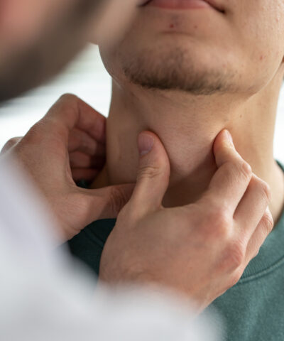 Doctor examining patient's throat at clinic