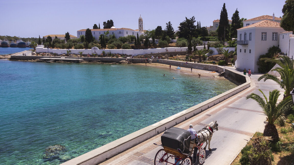 Spetses Island, Greece - May 14, 2017 : Horse drawn carriage on the way to the old harbor. Spetses, is a small picturesque island in the Saronic gulf, where the use of motorcars is not allowed.