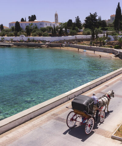 Spetses Island, Greece - May 14, 2017 : Horse drawn carriage on the way to the old harbor. Spetses, is a small picturesque island in the Saronic gulf, where the use of motorcars is not allowed.