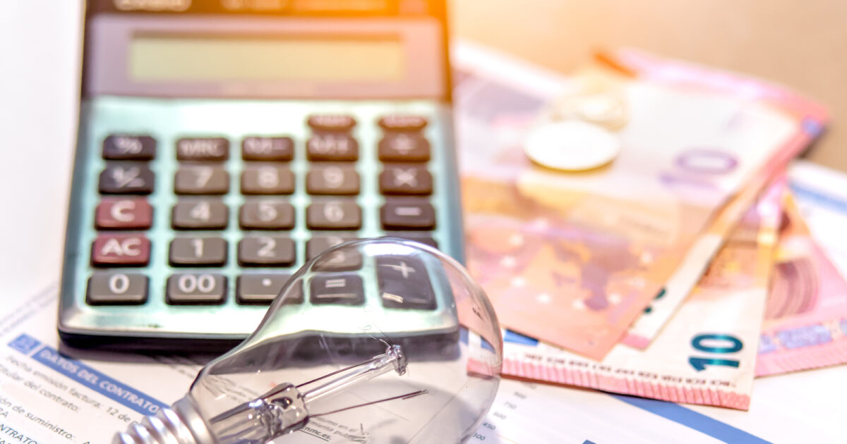 Electricity bill next to a calculator, a bulb and money. Electricity price concept.