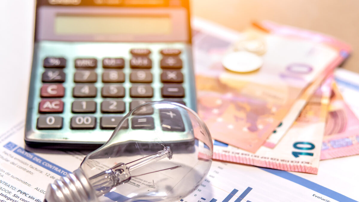 Electricity bill next to a calculator, a bulb and money. Electricity price concept.