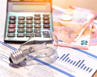 Electricity bill next to a calculator, a bulb and money. Electricity price concept.