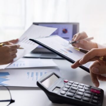 Team of Business people working at workplace with tablet and document, doing planning analyzing Tax financial report, business plan investment, finance analysis Economic business discussions