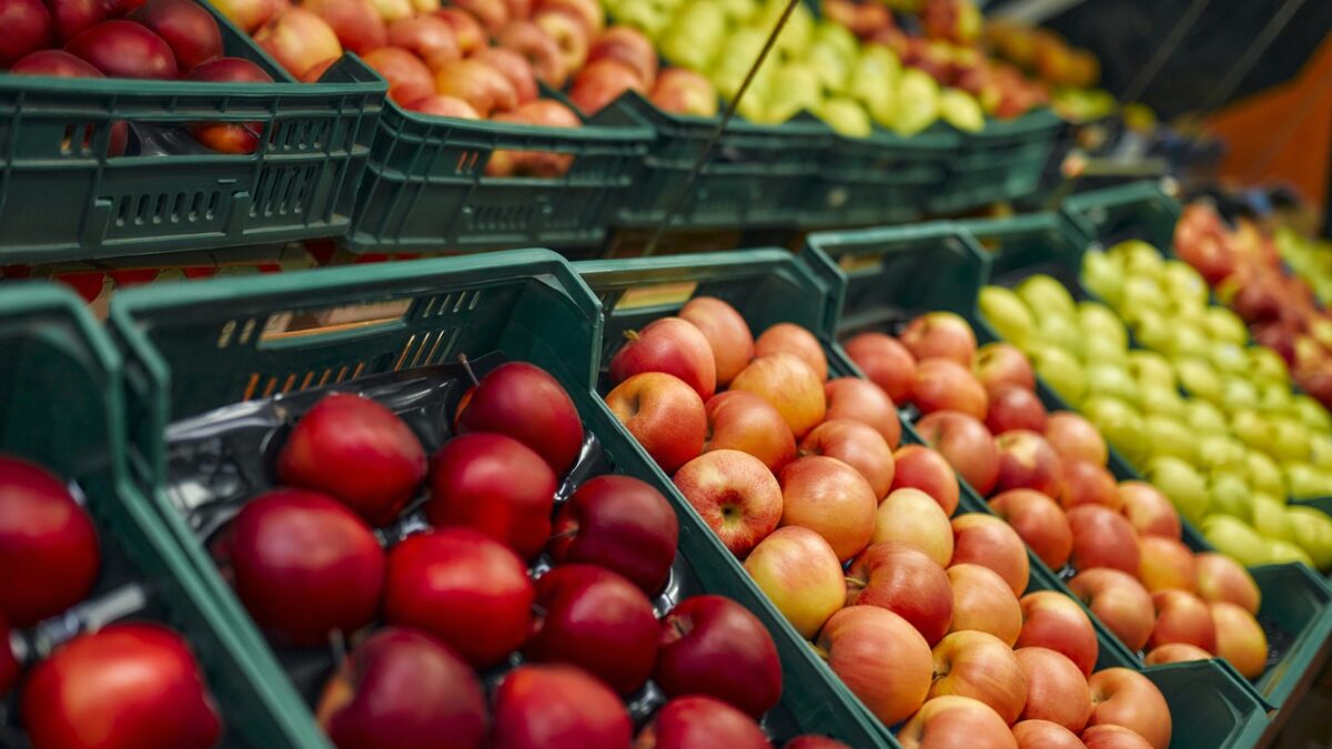 Crates of fresh fruit such as apples are for sale in the store. Buying vegetables and fruits at the market.