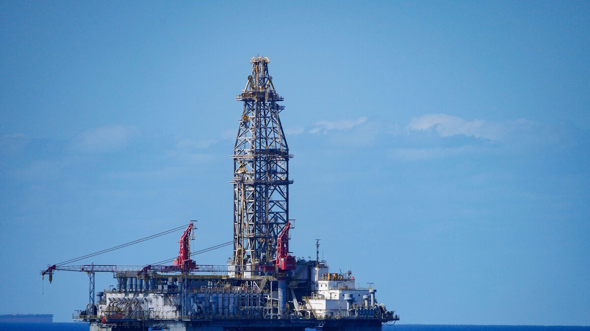 A large offshore oil rig in the middle of a vast expanse of ocean