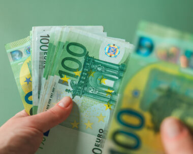 salary of a woman. euro banknotes in hands on a green background. Income of women in European countries