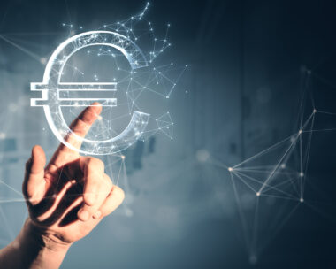 Close up of male hand pointing at creative polygonal euro sign on gray wall background. Online banking, money and trade concept