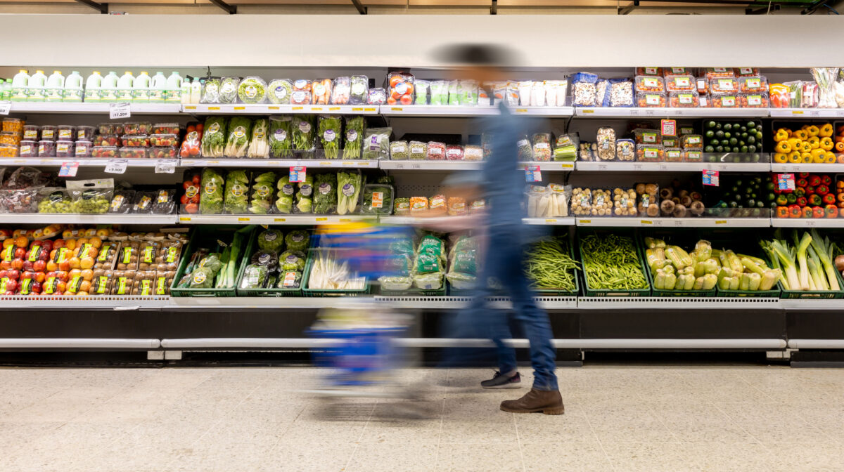 Man shopping at the supermarket pushing a shopping cart - blurred motion concepts
