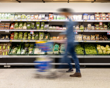 Man shopping at the supermarket pushing a shopping cart - blurred motion concepts