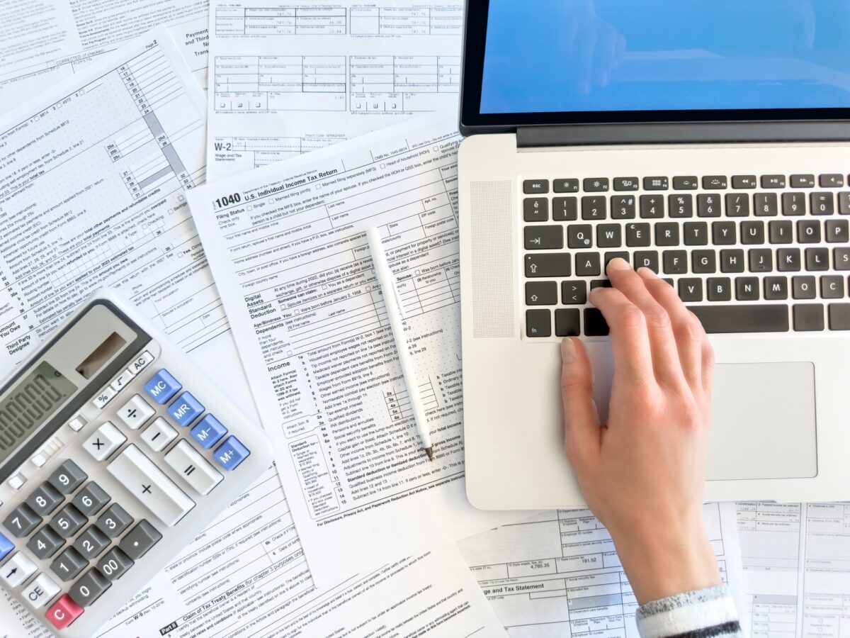 Doing taxes with laptop and tax forms in a house