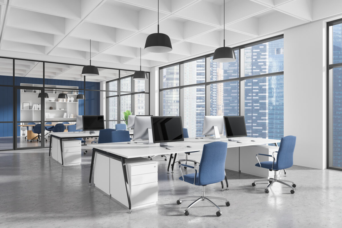 Contemporary office interior with ergonomic furniture, blue chairs, desks, and computers in a spacious area with large windows. Concept of workspace design. 3D Rendering