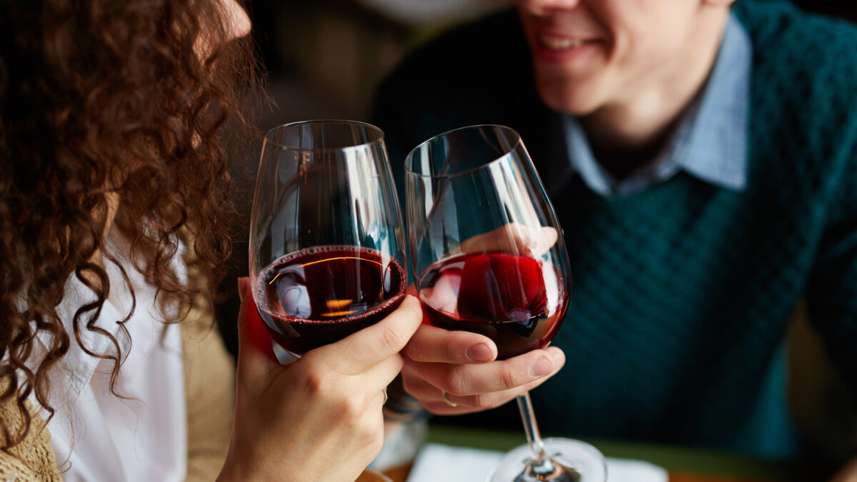 Amorous couple toasting with red wine in restaurant