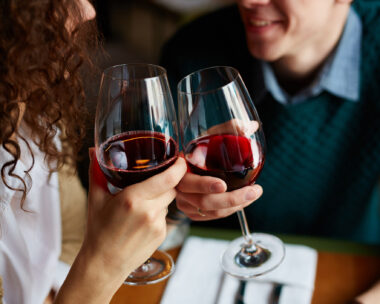 Amorous couple toasting with red wine in restaurant