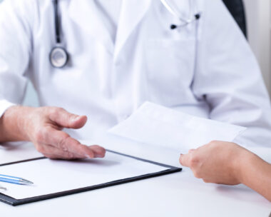 Senior male doctor and payment for private consultation
