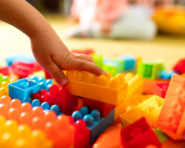 Close-up of unrecognizable child playing with plastic blocks.