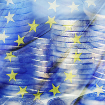 a multiple exposure of some piles of euro coins and a flag of the European Union