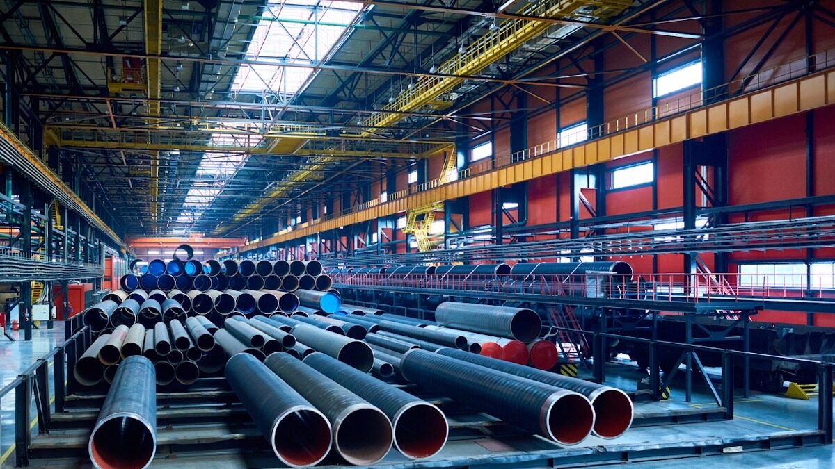 Abundance of tubes used for oil and gas industry placed in factory warehouse