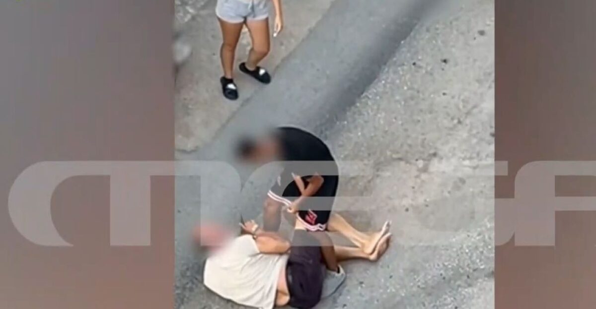 Ο ηλικιωμένος έχει πέσει στον δρόμο και δέχεται τα χτυπήματα από τον ανήλικο