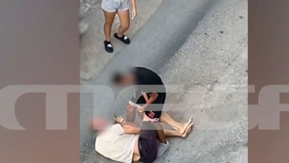 Ο ηλικιωμένος έχει πέσει στον δρόμο και δέχεται τα χτυπήματα από τον ανήλικο