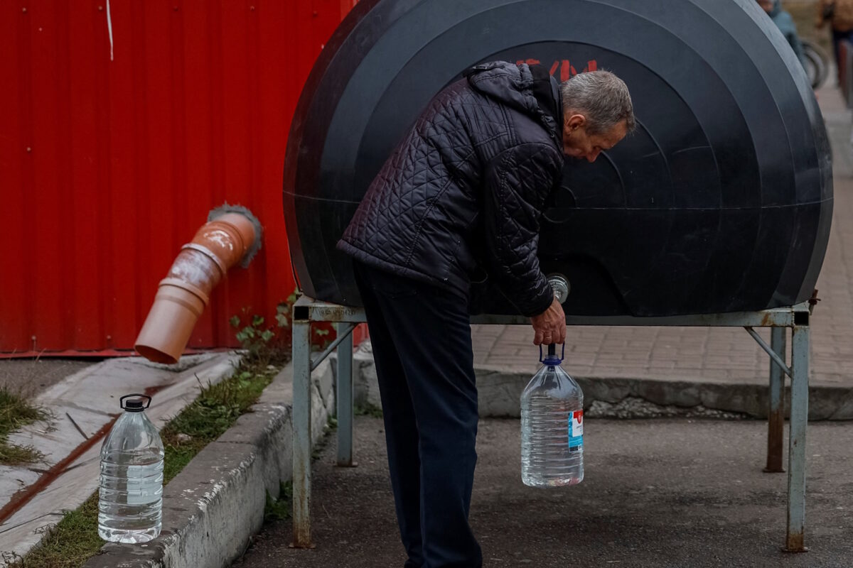 Ουκρανός γεμίζει μπουκάλι με νερό λόγω της διακοπής νερού από την ρωσική επίθεση στο Τσερνίχιβ