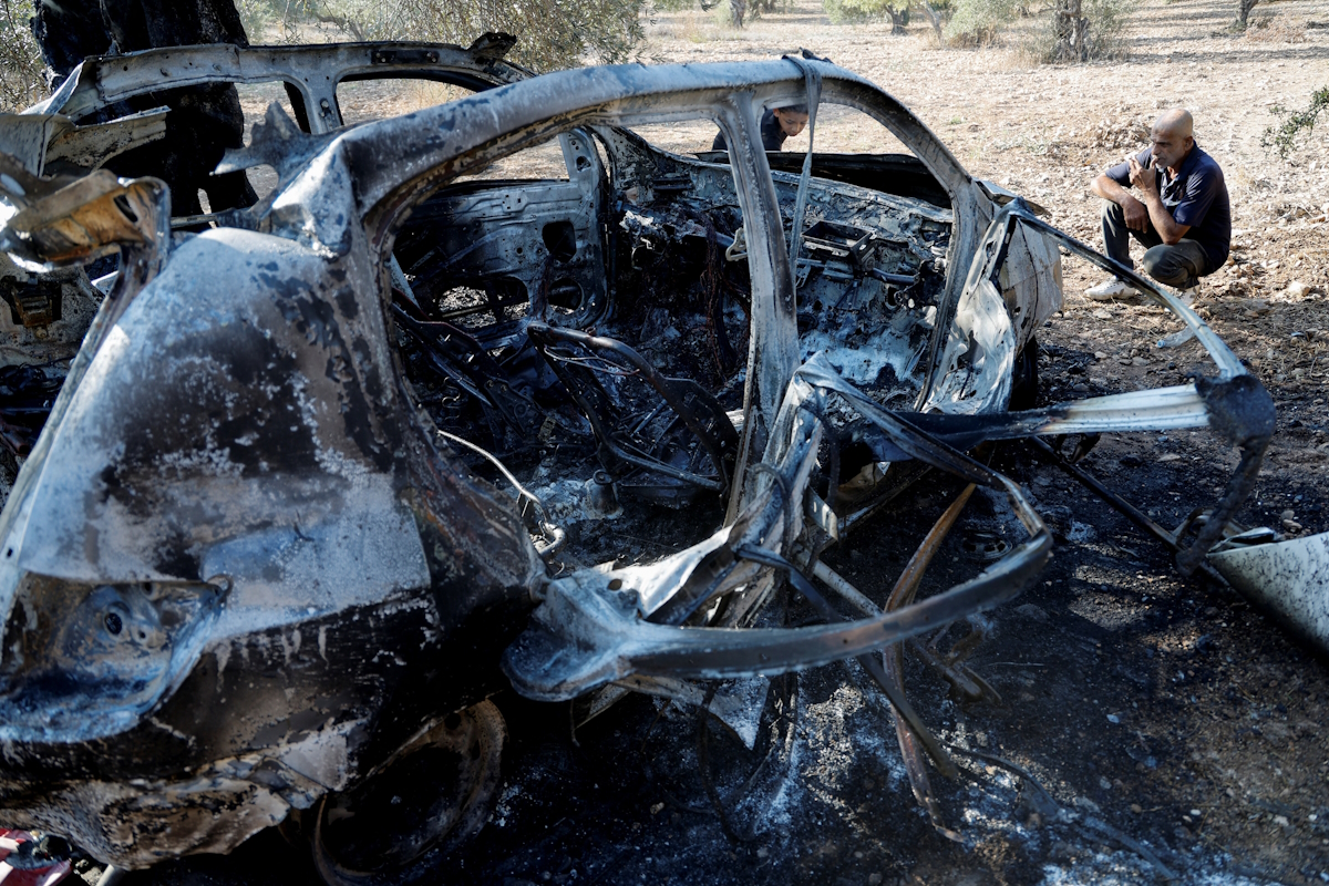 Παλαιστίνιος μπροστά από καμένο αυτοκίνητο στους νέους ισραηλινούς βομβαρδισμούς στη Λωρίδα της Γάζας