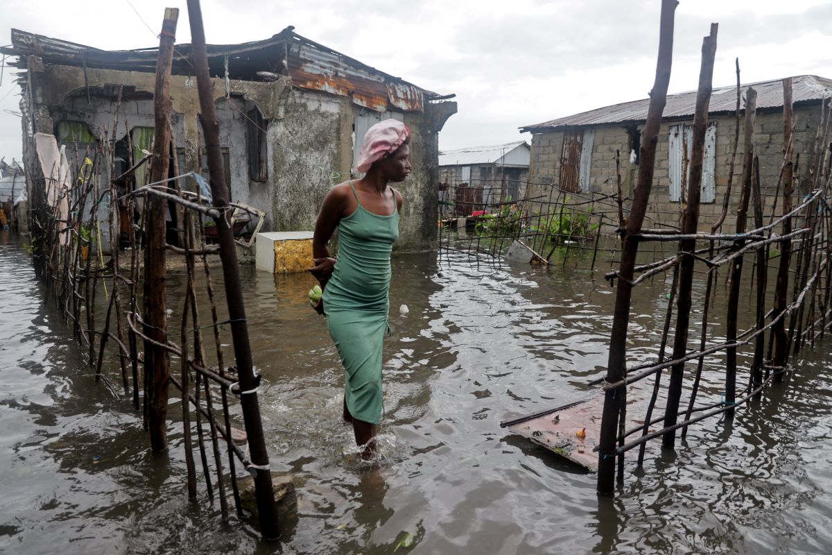 A resident of Haiti stands outside her damaged home due to Hurricane Melissa