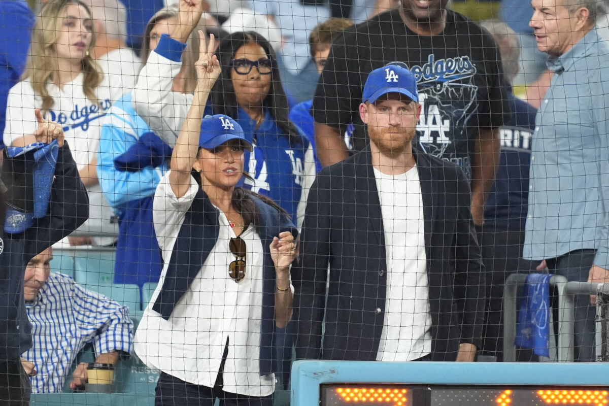 Oct 28, 2025; Los Angeles, California, USA; Prince Harry (right) and Meghan Markle (left) cheer in the seventh inning between the Toronto Blue Jays and the Los Angeles Dodgers during game four of the 2025 MLB World Series at Dodger Stadium. Mandatory Credit: Kirby Lee-Imagn Images