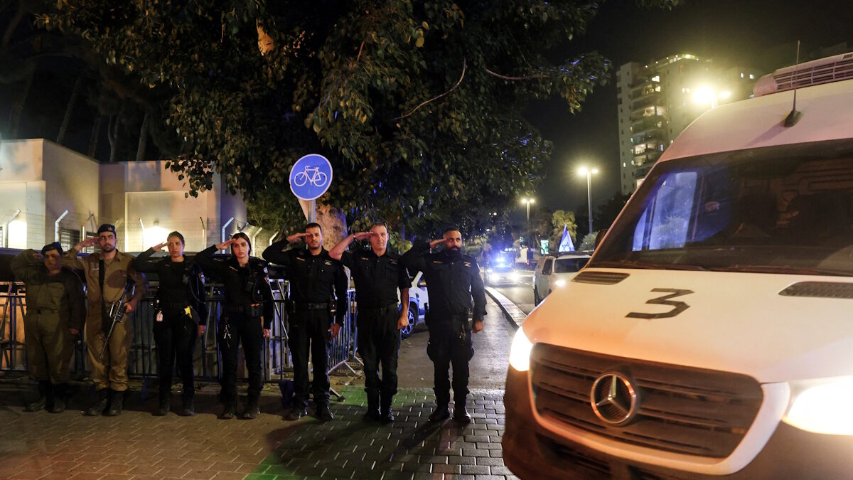 Ισραηλινοί αστυνομικοί και στρατιώτες χαιρετούν καθώς περνά από μπροστά τους κονβόι που μεταφέρει τα πτώματα των δύο ομήρων