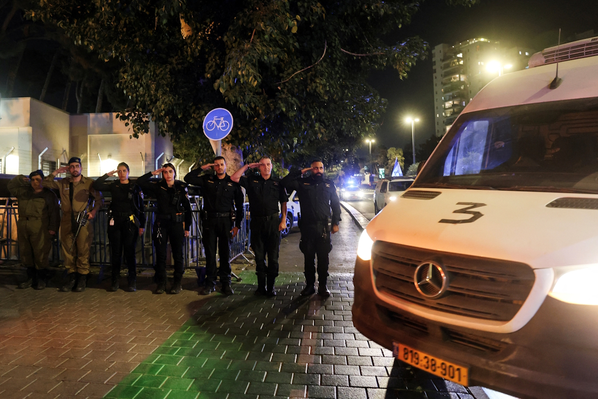Ισραηλινοί αστυνομικοί και στρατιώτες χαιρετούν καθώς περνά από μπροστά τους κονβόι που μεταφέρει τα πτώματα ομήρων