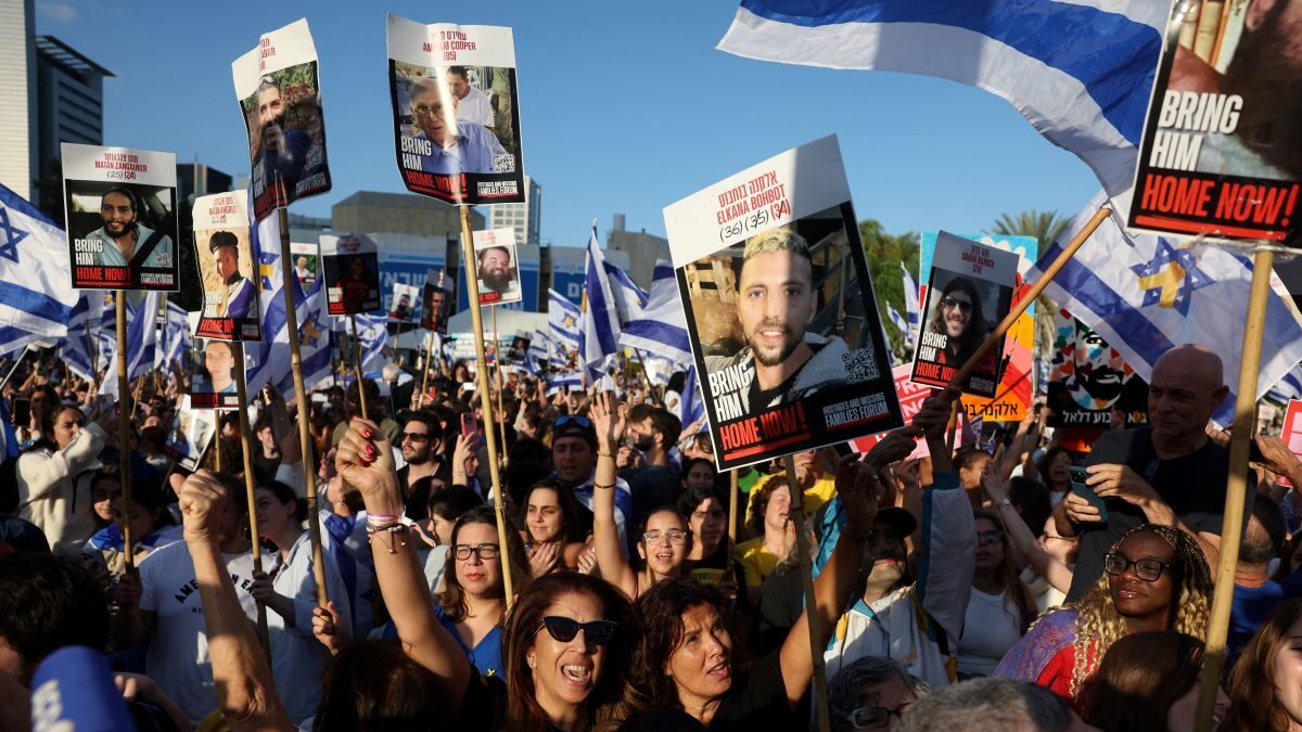 Ισραηλινοί πολίτες με πλακάτ με τις φωτογραφίες των ομήρων