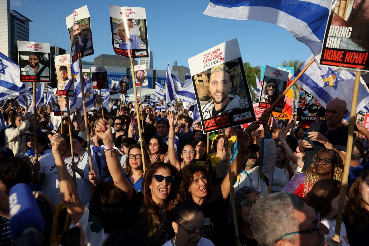 Ισραηλινοί πολίτες με πλακάτ με τις φωτογραφίες των ομήρων