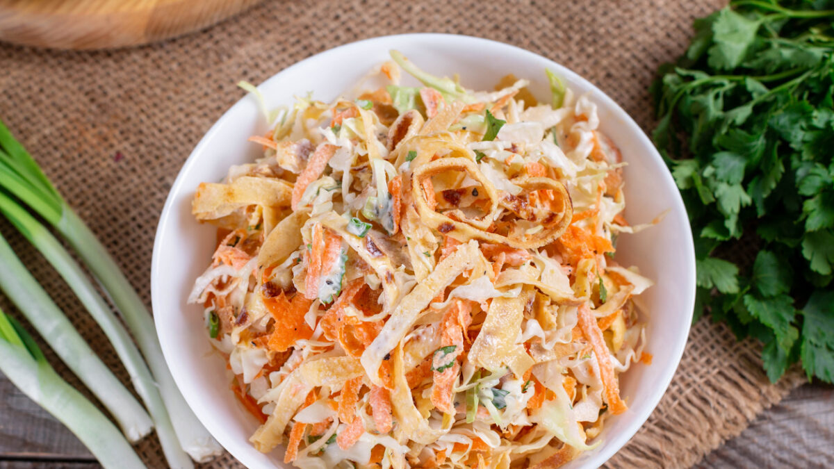 Salad with cabbage and carrots in a white plate on the table