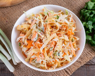 Salad with cabbage and carrots in a white plate on the table
