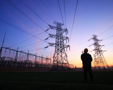 Electricity workers and pylon silhouette