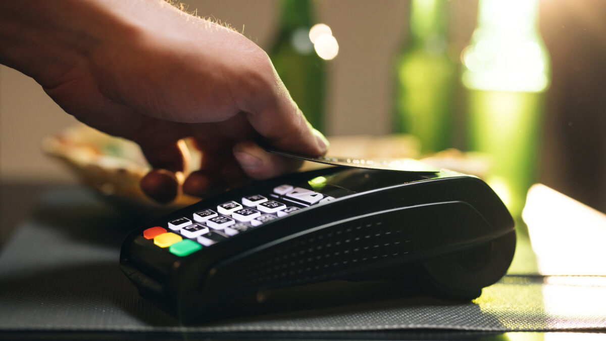 Credit card machine for money transaction. Close up of male hold in hand wireless modern bank payment terminal to process acquire credit card payments black card. Credit card through pos terminal.