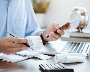 young man holding pen with bills working for calculate business data, taxes, bills payment,