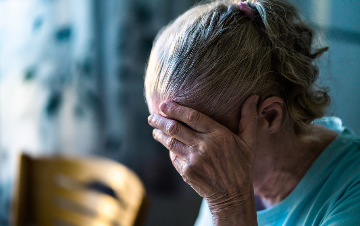 Sad senior old woman. Lonely from loss or sick with headache. Upset patient in retirement home with stress or pain. Alzheimer, depression, senility or dementia. Disorder, migraine or insomnia.