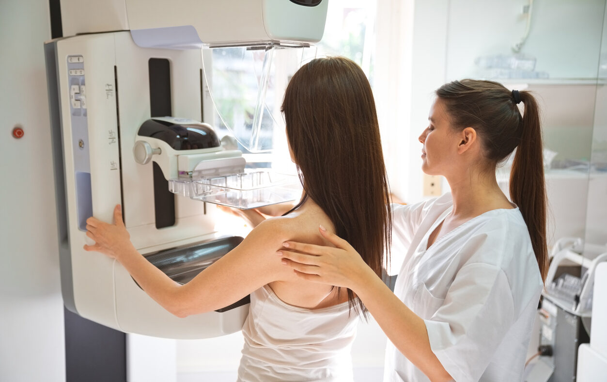 Female doctor and mid adult woman during Mammography test in examination room.