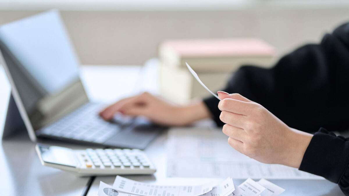 Asian woman entering expenses in accounting software
